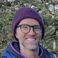 Ali, smiling, in a woolly hat